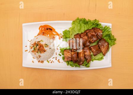 suckling pig kawali, a Filipino dish made from crispy fried pork belly garnished with white rice with vegetables Stock Photo