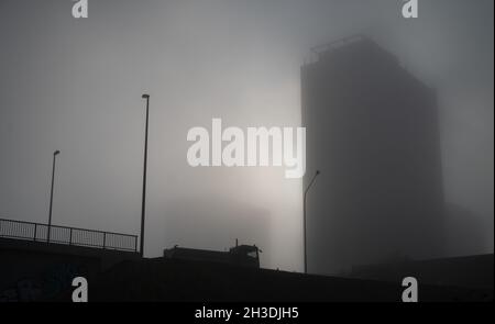 28 October 2021, Hessen, Frankfurt/Main: A truck drives past skyscrapers disappearing in the fog in the Frankfurter Berg district. Photo: Sebastian Gollnow/dpa Stock Photo