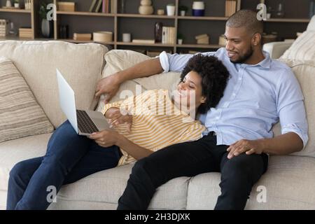 Happy relaxed young african american family couple using computer. Stock Photo
