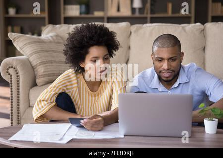 Focused young african american couple planning investment. Stock Photo