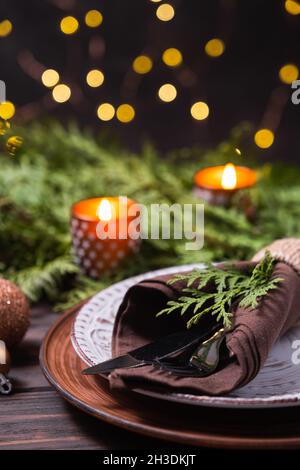 Christmas table setting with decorations, fir branches and candles. Stock Photo