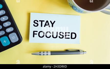 Stay focused - text on sticker with pen, coffee cup and calculator Stock Photo