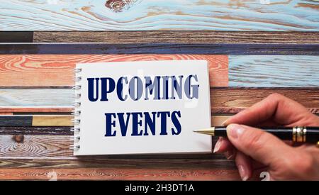 Concept message on a notebook is written by a female hand on a wooden table. Stock Photo