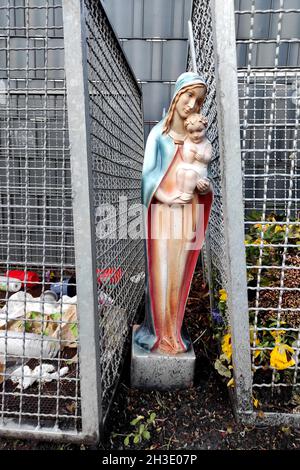 holy Virgin Mary statue with baby Jesus in garbage on a cemetery , Germany, North Rhine-Westphalia Stock Photo