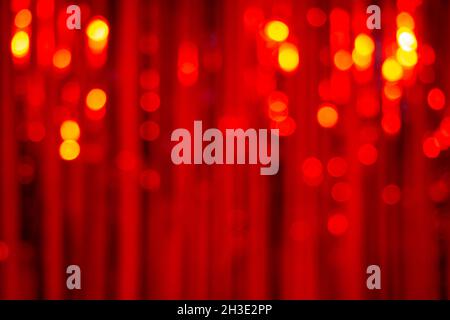 Background of a blurred red party glitter curtain with lights bokeh Stock Photo