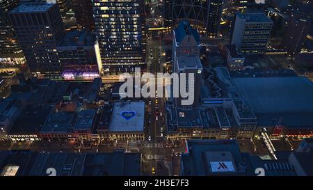 Beautiful high angle view of Calgary downtown, Canada with illuminated buildings in the evening and driving cars on the streets. Stock Photo