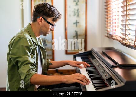 Cropped unrecognizable female doctor in white robe taking notes on clipboard and sitting on chair in modern clinic Stock Photo