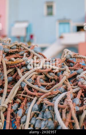 Heap of colorful ropes with metal elements placed in street against residential building in daylight Stock Photo
