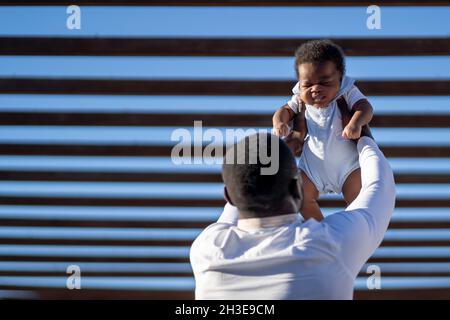 Calm senior male with bald head and long gray beard leaning on fence in park and confidently looking away Stock Photo