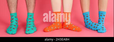 Legs in different socks on pink background Stock Photo