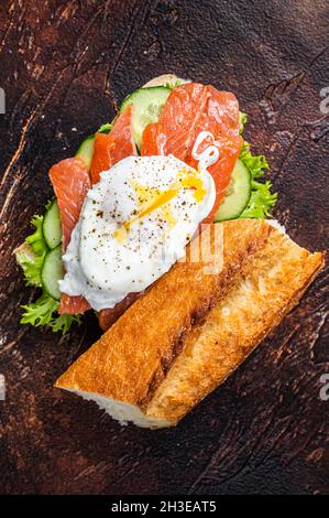 Poached egg with smoked salmon and avocado on toast. Dark background. Top view Stock Photo