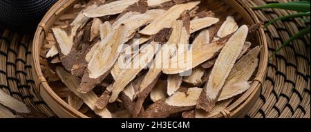 Close up of Chinese traditional herbal medicine Astragalus root on wooden table background. Stock Photo