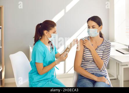 Doctor vaccinate female patient against corona virus Stock Photo