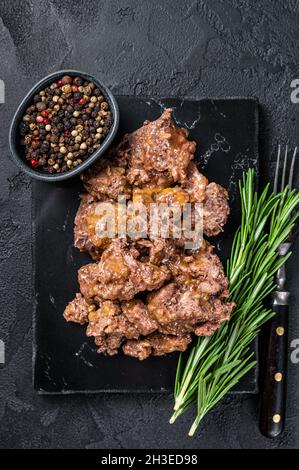 Stewed lamb and beef meat on a marble board. Black background. Top view Stock Photo