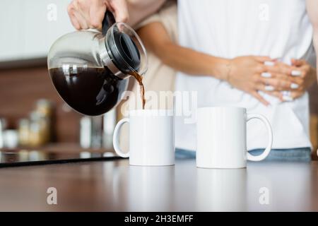 cropped view of man pouring coffee into cup Stock Photo