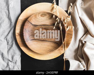 Round wooden craft plates mockup for eco, food or beauty product on black and textile backgrounds. Top view. Copy space Stock Photo