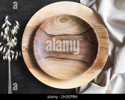 Round wooden craft plates mockup for eco, food or beauty product on black and textile backgrounds. Top view. Copy space Stock Photo