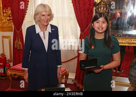 The Duchess of Cornwall presents Junior Winner from 2020, Cassandra Nguyen with a pen during a reception for winners of The Queen's Commonwealth Essay Competition 2021 at St James's Palace in London. Picture date: Thursday October 28, 2021. Stock Photo