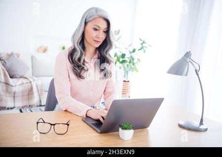Portrait of attractive focused woman copywriter using laptop writing typing e-mail at home house indoor Stock Photo