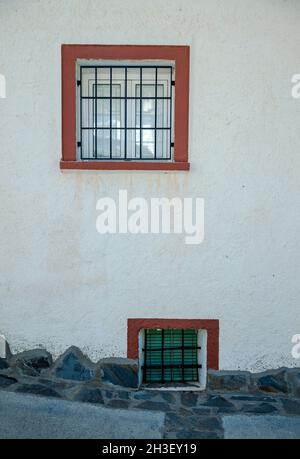 Two small windows with red frame on white wall Stock Photo