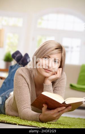 Smiling woman reading book Stock Photo