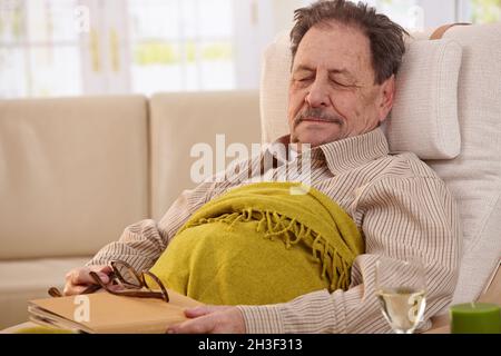 Senior man sleeping in armchair Stock Photo