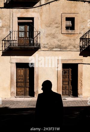 Silhouette of adult man in front of facade of an old building in Sepulveda, Spain Stock Photo
