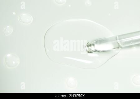 Drops from a pipette. Liquid gel or serum on a microscope screen on a white background Stock Photo