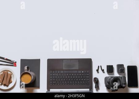 flat lay, coffee, wafer, stationery and all the gadgets, come under the frame Stock Photo