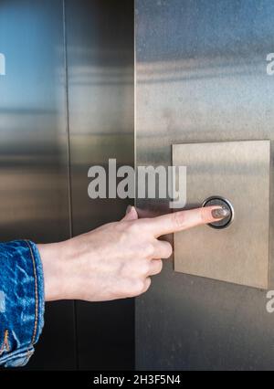 female hand pressing the button to call the elevator. High quality photo Stock Photo