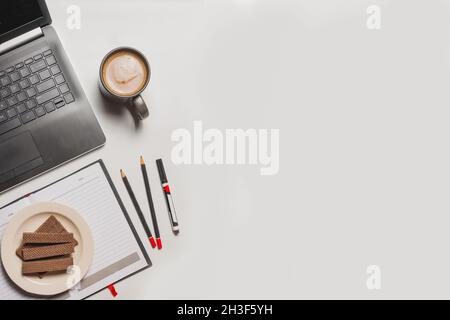 flat lay, coffee, wafer, stationery and laptop Stock Photo