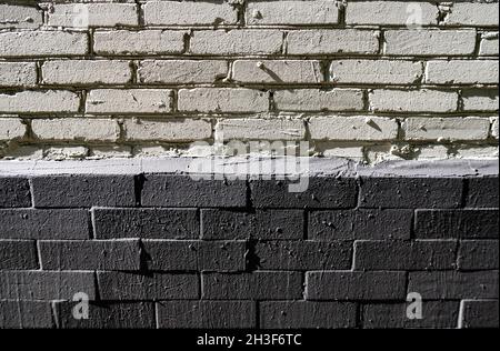 wall made of bricks of two colors white and gray in the sun. High quality photo Stock Photo