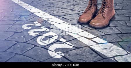 Feet in boots on the cobblestones road in front of the text 2022. Concept of the New Year, new solutions and motivation. Stock Photo