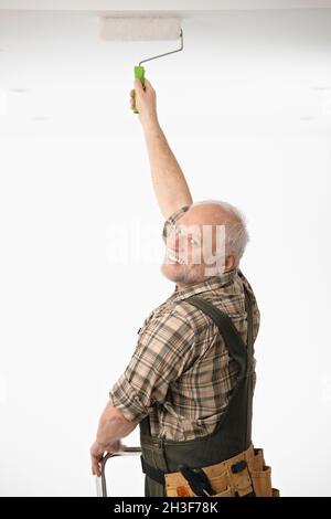 Elderly man painting the ceiling Stock Photo