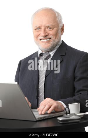 Happy senior businessman using computer Stock Photo