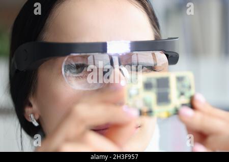 Master repairman in goggles looking at computer microchip Stock Photo