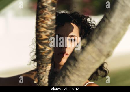 Closeup shot of a Spanish female gazing through the trees Stock Photo