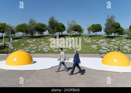 Santiago, Metropolitana, Chile. 28th Oct, 2021. Two men walk in front of two giant fried eggs that are part of an intervention in the Parque de la Familia, as part of the Made at Home Fest, in Santiago, Chile. (Credit Image: © Matias Basualdo/ZUMA Press Wire) Credit: ZUMA Press, Inc./Alamy Live News Stock Photo