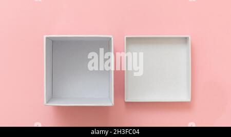 Gift box white empty, open cover on pastel pink background, top view. Blank space, branding template, product presentation Stock Photo
