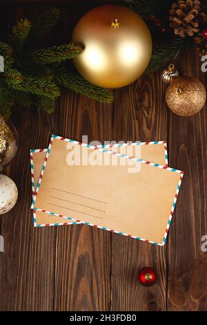 Christmas craft envelope mockup. White minimal empty letter on wooden table with festive decorations. Stock Photo