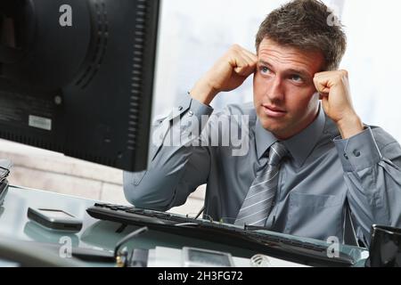 Businessman thinking at desk Stock Photo