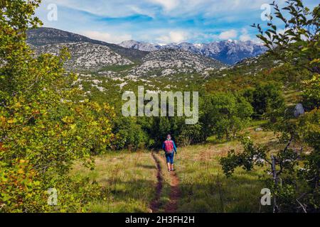 Solitary female in the Karst scenery of the Limestone mountains, Velebit mountains, Dinaric Alps, Croatia Stock Photo