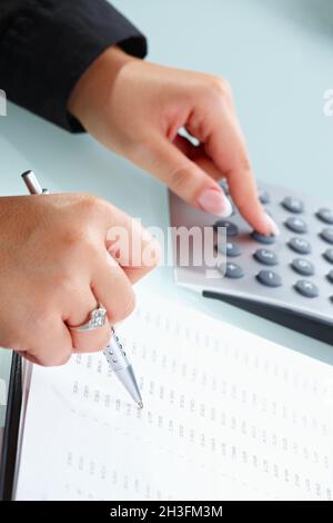 Female hands using calculator Stock Photo