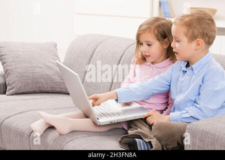 Siblings using laptop computer Stock Photo