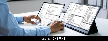 Computer Programmer Writing Program Code On Computer In Office Stock Photo