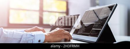 Computer Programmer Writing Program Code On Computer In Office Stock Photo