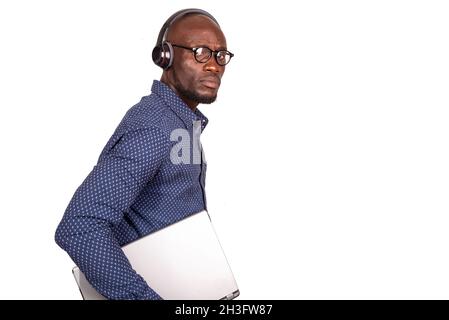 handsome businessman standing on white background with headset looking at camera while holding laptop Stock Photo