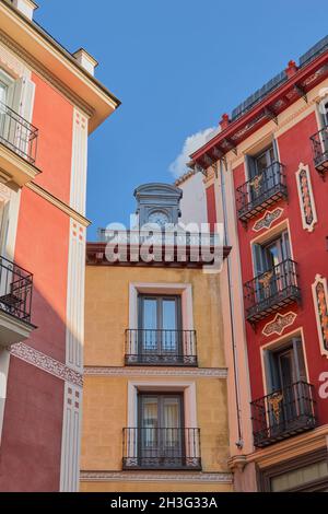 Plaza Mayor,Madrid,Spain;September 16 2018:View of an alley with picturesque red and yellow buildings and adorned with an antique clock in the central Stock Photo