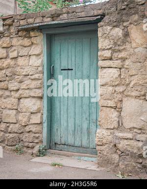 Green wooden door in the stone fence old-fashioned Stock Photo