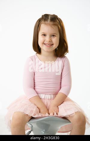 Little girl sitting on chair Stock Photo